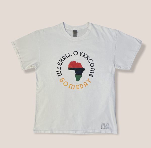 White tshirt with red black and green colored Africa, encircled by the words 'We Shall Overcome Someday"