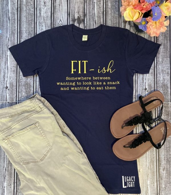 Navy blue tee shirt with yellow writing that says: "Fit-ish: Somewhere between wanting to look like a snack and wanting to eat them"